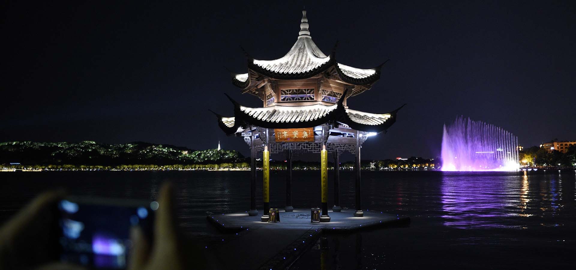 Tourists view night scene of West Lake in Hangzhou