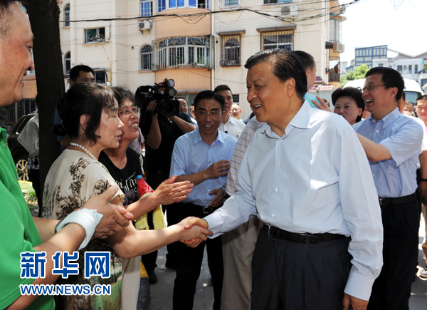 这是7月22日，刘云山在上海市普陀区桃浦镇莲花公寓居委会调研时同社区居民亲切握手。新华社记者 饶爱民 摄